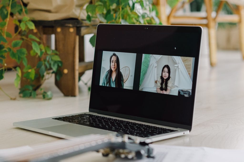 pexels photo 7574366 7574366 A laptop displays a virtual meeting between a woman and a girl in a home setting with plants.