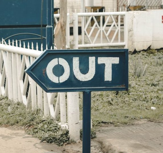 an exit sign reading 'OUT' learning phrasal verbs with 'out'
